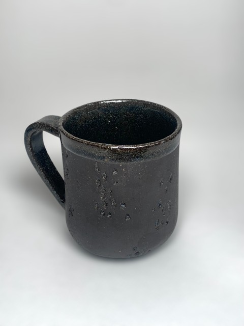 Taza pasta negra interior y bajorelieve azul cobalto. Exterior pasta expuesta